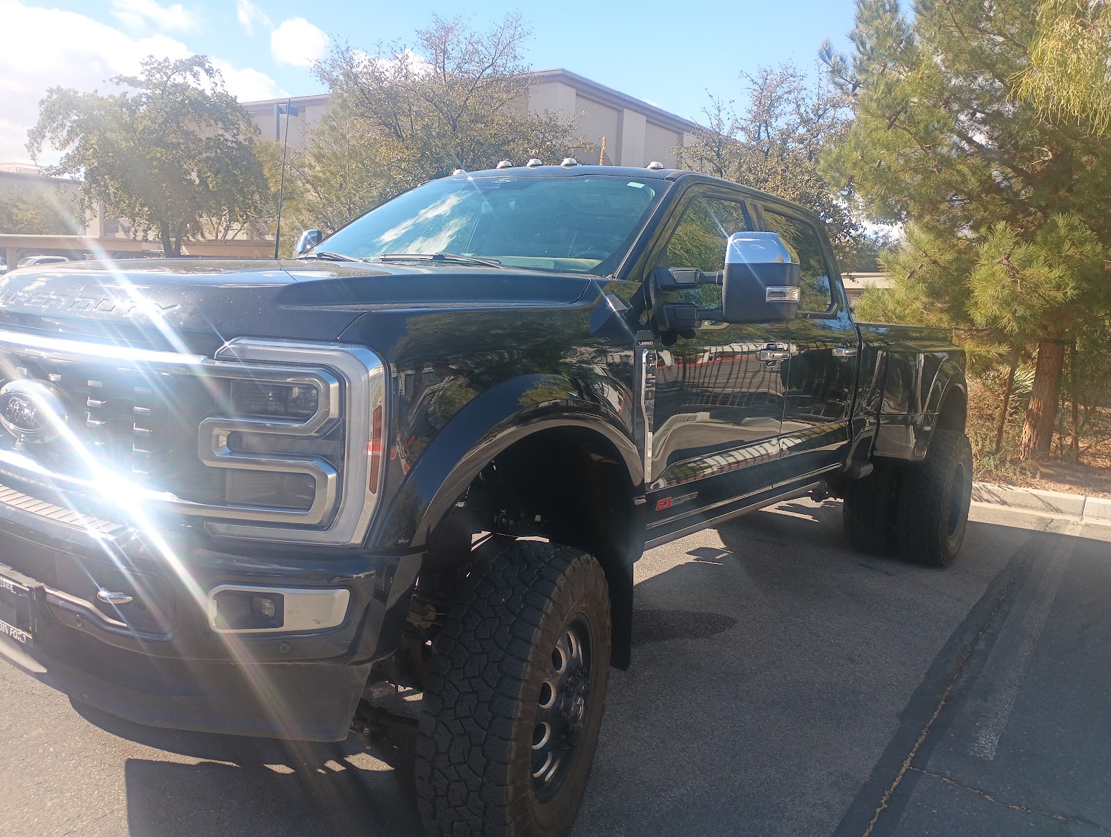 Black lifted Ford F-350 Super Duty Platinum dually truck parked outdoors