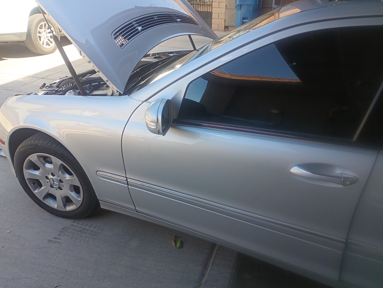 Silver Mercedes-Benz sedan with hood open during service