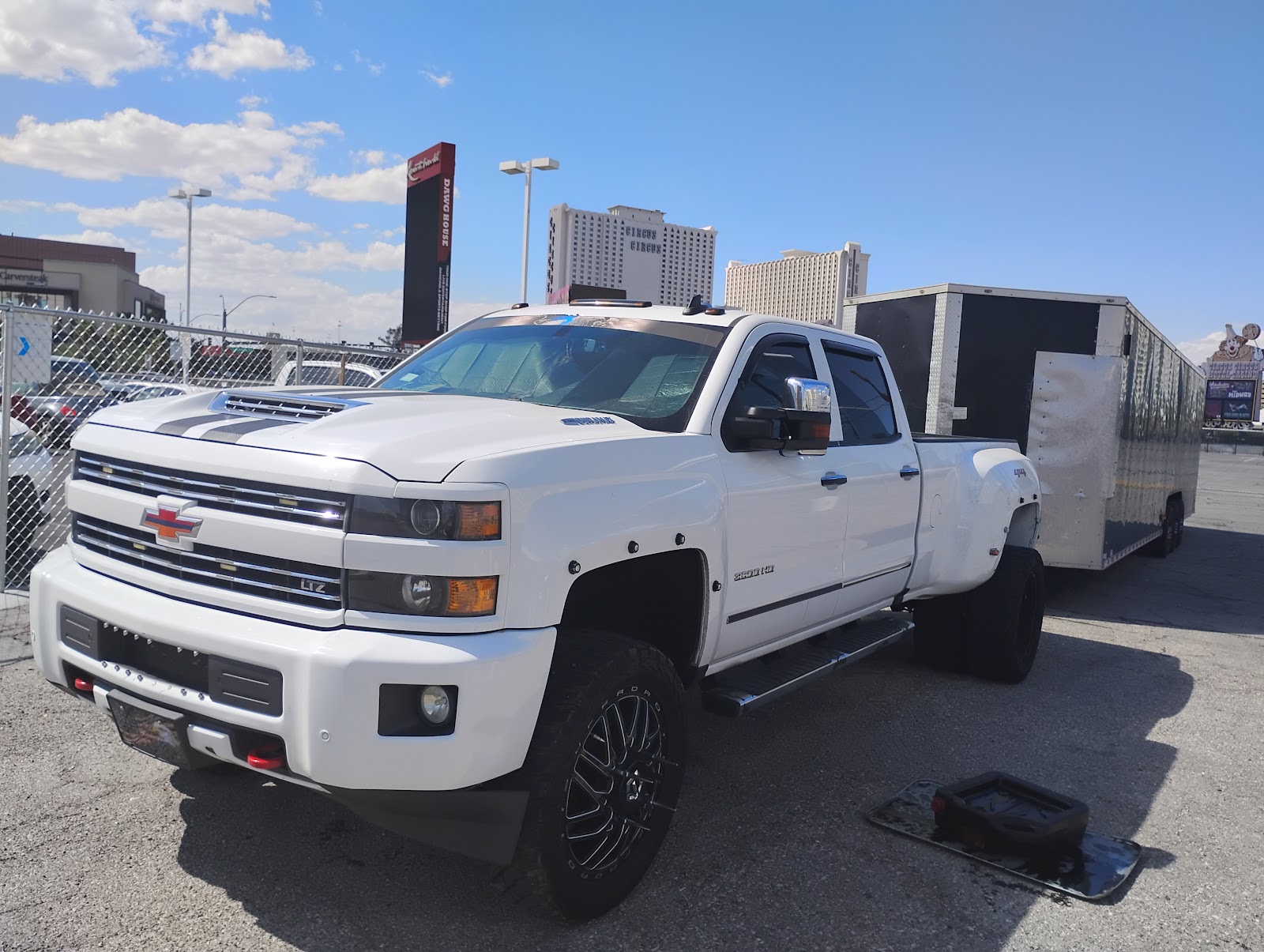 White Chevrolet Silverado 3500HD LTZ dually truck with enclosed trailer in a Las Vegas lot